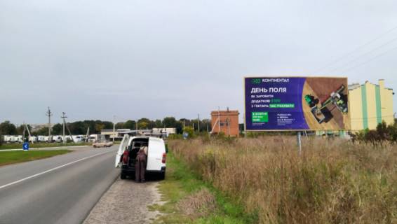 Билборд A в Радехове, 6x3м.  м. Радехів, вул. Галицька, 4, вїзд в місто з напрямку м. Львів, м. Камянка - Бузька, на м. Червоноград, м. Луцьк, траса Львів - Луцьк (Н-17) + АЗК + жовта вітрозахисна люмінесцентна рамка + висока конструкція, поряд АЗК Укрнафта, на ТЦ АТБ фото 1